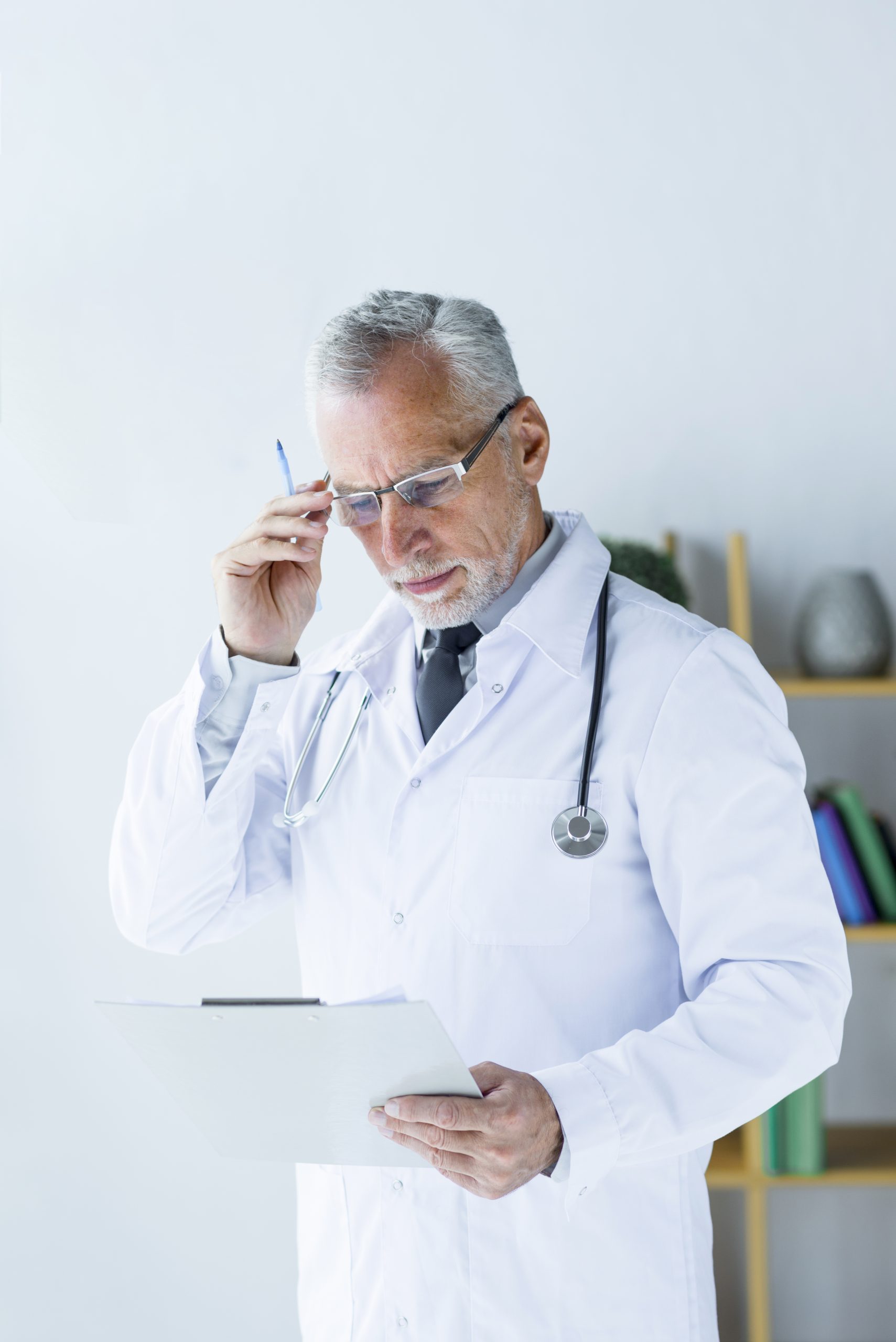 elderly doctor reading records